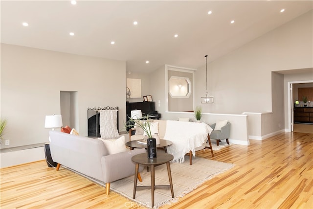 living room with light hardwood / wood-style floors and high vaulted ceiling