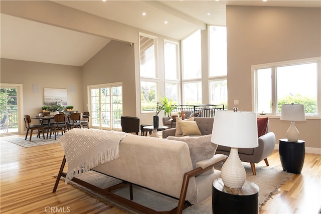 interior space featuring light hardwood / wood-style flooring, high vaulted ceiling, and beamed ceiling