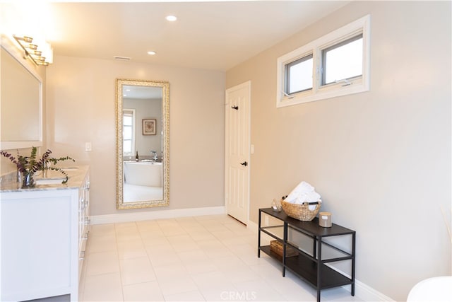 bathroom with a tub and vanity