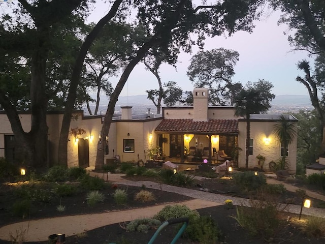 back house at dusk with a patio