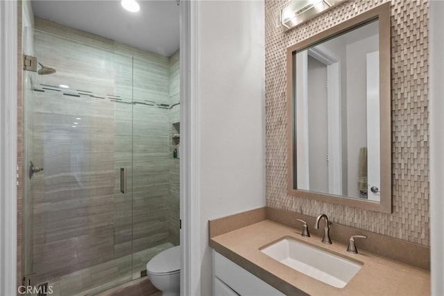 bathroom with vanity, toilet, and a shower with shower door