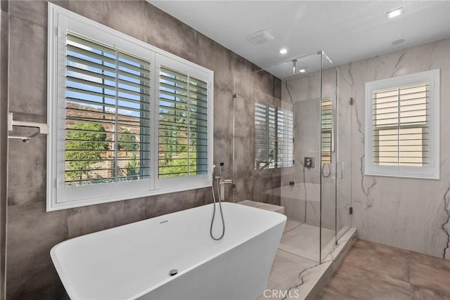 bathroom featuring shower with separate bathtub and plenty of natural light