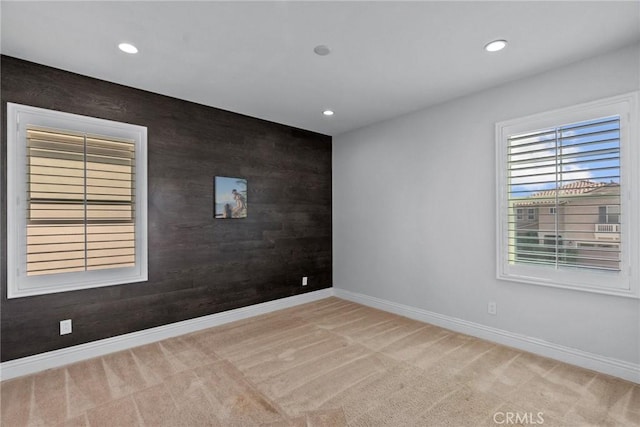 empty room with light carpet and wooden walls