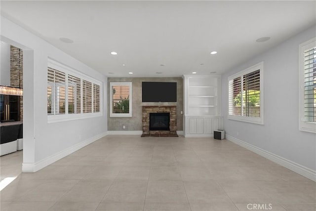 unfurnished living room featuring a stone fireplace and light tile patterned flooring