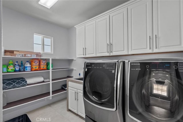 clothes washing area with cabinets and independent washer and dryer