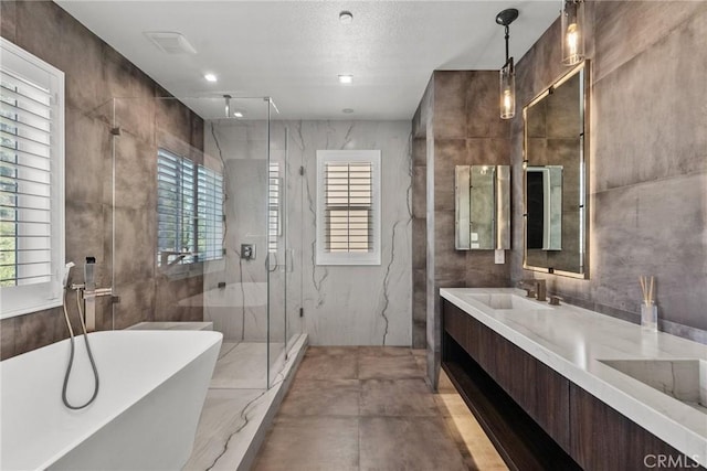 bathroom featuring vanity, tile walls, and independent shower and bath