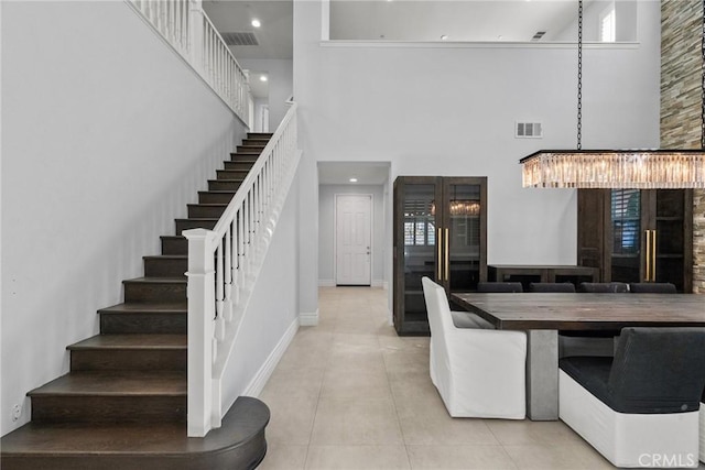 interior space with tile patterned flooring, a high ceiling, and a chandelier