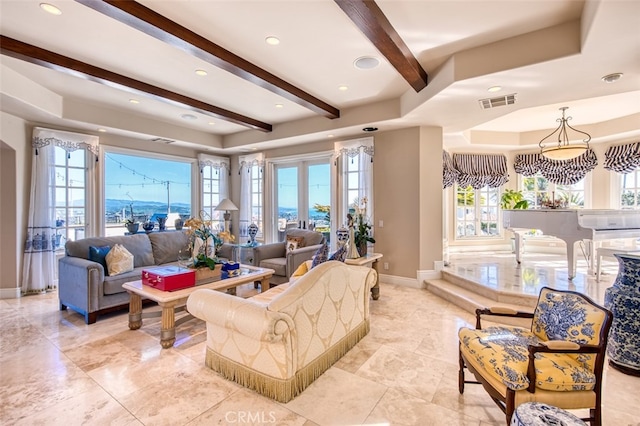 living room featuring a healthy amount of sunlight and beamed ceiling