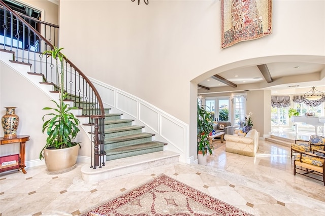 entrance foyer featuring a high ceiling and beam ceiling