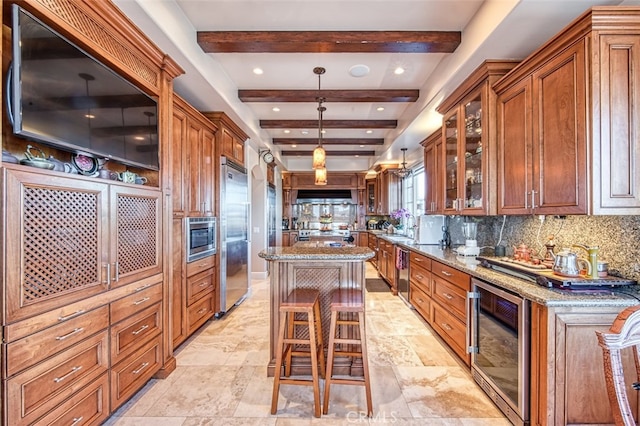 kitchen with wine cooler, light stone counters, a kitchen island, pendant lighting, and beam ceiling