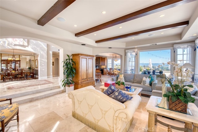 living room with a chandelier and beam ceiling