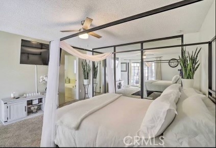 bedroom with light carpet, a textured ceiling, ensuite bathroom, and ceiling fan