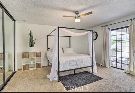 carpeted bedroom with ceiling fan and a textured ceiling