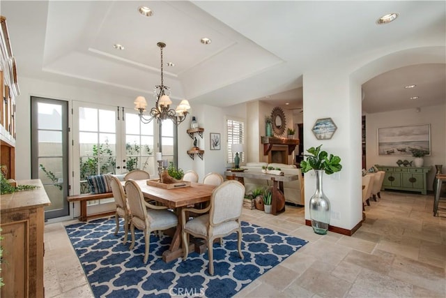 dining space with a chandelier and a tray ceiling