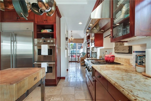 kitchen featuring ventilation hood, light stone countertops, and appliances with stainless steel finishes