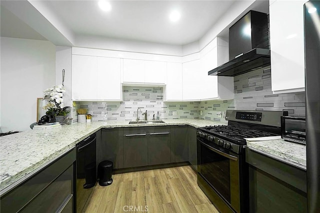 kitchen featuring wall chimney range hood, sink, black appliances, white cabinets, and light stone counters