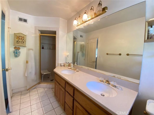 bathroom with tile patterned flooring, vanity, and an enclosed shower