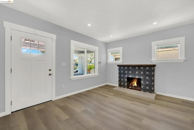 entrance foyer featuring light wood-type flooring and a tile fireplace