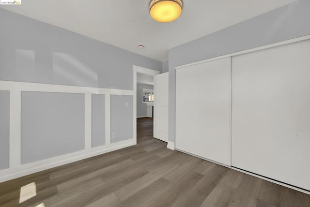 unfurnished bedroom with a closet and hardwood / wood-style flooring