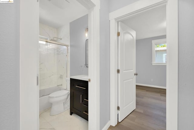 full bathroom featuring enclosed tub / shower combo, vanity, toilet, and hardwood / wood-style flooring