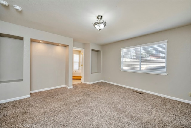 unfurnished bedroom featuring multiple windows and carpet flooring