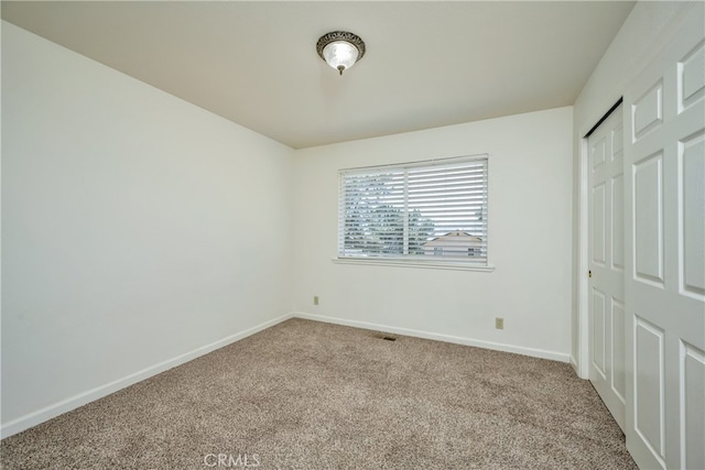 unfurnished bedroom with a closet and light colored carpet