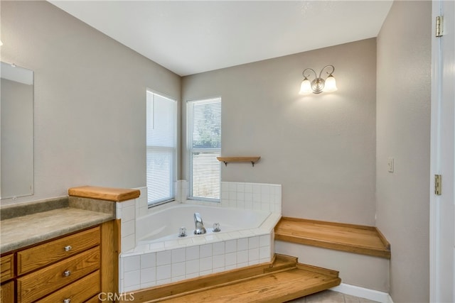 bathroom with tiled tub and vanity