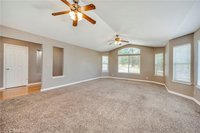 empty room with carpet flooring, vaulted ceiling, and ceiling fan