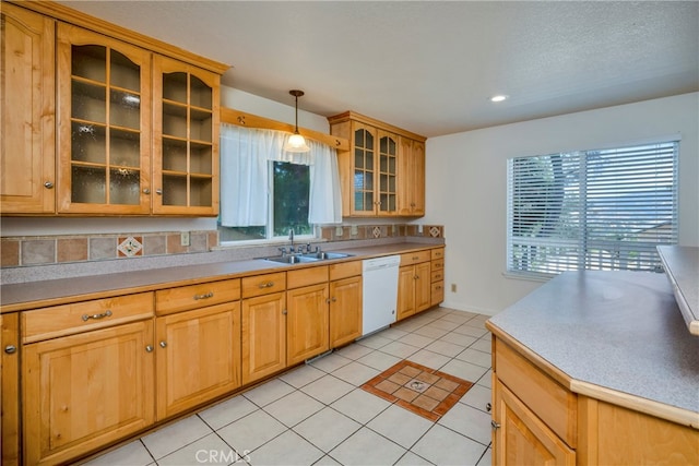 kitchen featuring dishwasher, hanging light fixtures, light tile patterned floors, and sink