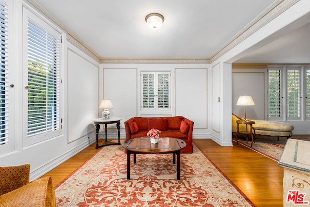 living room with hardwood / wood-style floors and crown molding