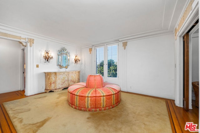 living area with wood-type flooring and crown molding