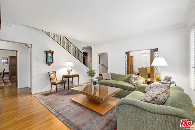 living room featuring ornamental molding, hardwood / wood-style floors, and a notable chandelier