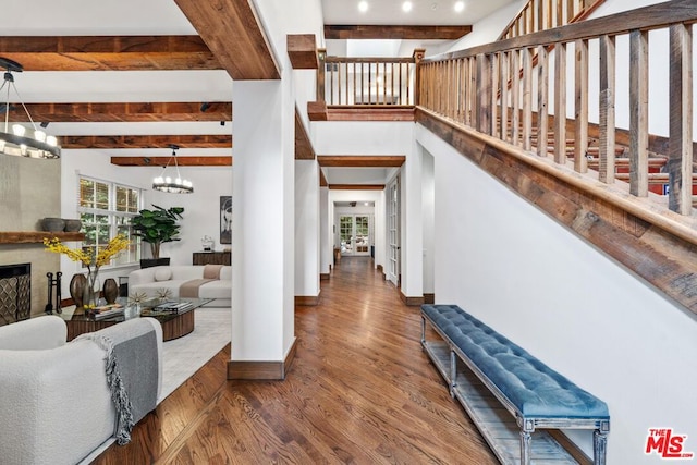 interior space with beamed ceiling, dark wood-type flooring, and a notable chandelier