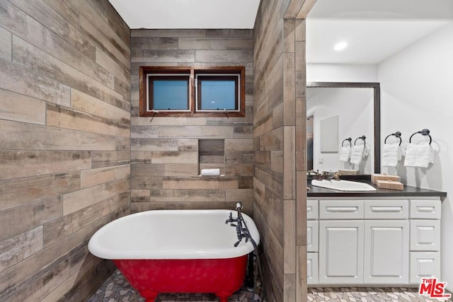 bathroom with wooden walls, a bathing tub, and vanity