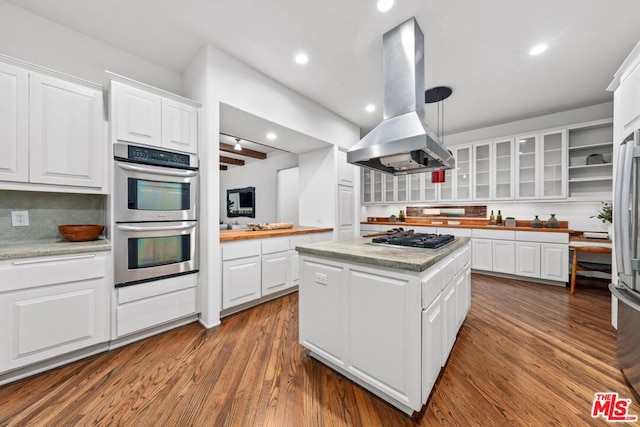 kitchen featuring a center island, hardwood / wood-style flooring, white cabinetry, island exhaust hood, and stainless steel appliances