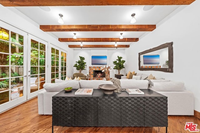 living room featuring wood-type flooring, beamed ceiling, and french doors