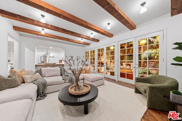 living room featuring hardwood / wood-style floors, beamed ceiling, and french doors