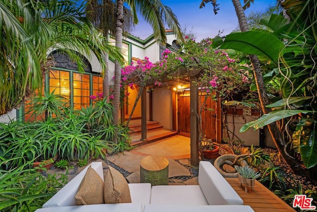 patio terrace at dusk featuring an outdoor hangout area