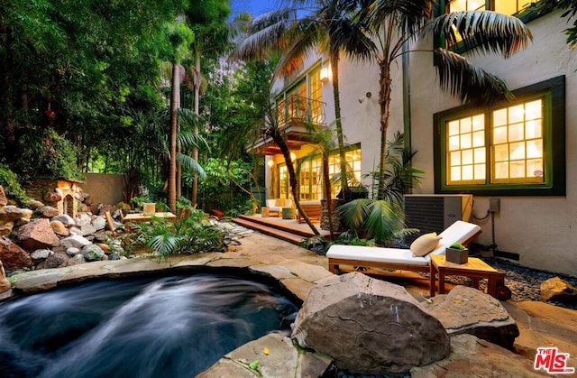 view of pool with a jacuzzi, central AC unit, and a patio area