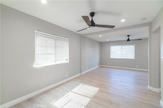 empty room with ceiling fan and light wood-type flooring