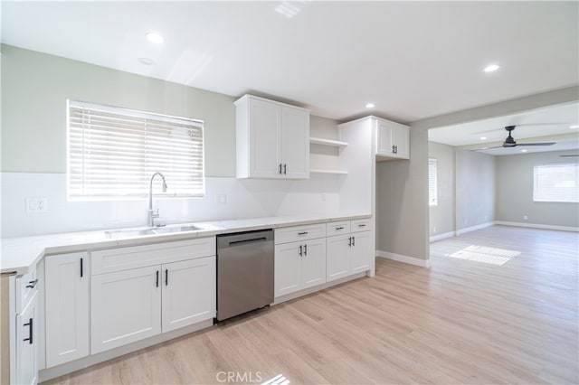 kitchen featuring ceiling fan, sink, light hardwood / wood-style flooring, stainless steel dishwasher, and white cabinets