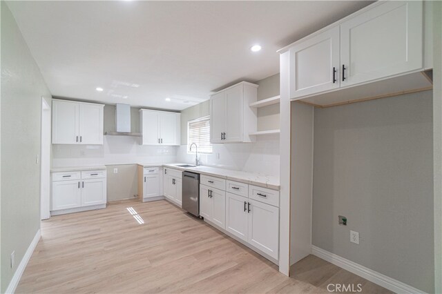 kitchen featuring dishwasher, light hardwood / wood-style flooring, white cabinetry, and wall chimney range hood