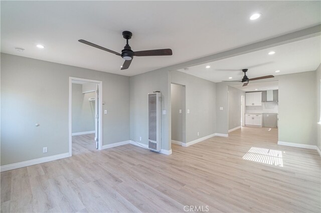 unfurnished living room featuring ceiling fan and light wood-type flooring