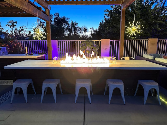 view of patio featuring a pergola, exterior bar, and a fire pit