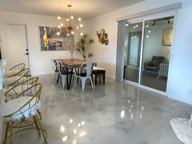 dining room featuring concrete floors and an inviting chandelier