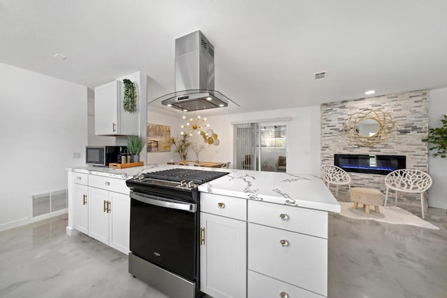 kitchen featuring white cabinetry, island exhaust hood, a large fireplace, and gas stove