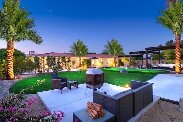 patio terrace at dusk featuring a yard, a pergola, and outdoor lounge area