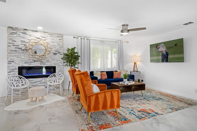 living room featuring a large fireplace, concrete flooring, and ceiling fan