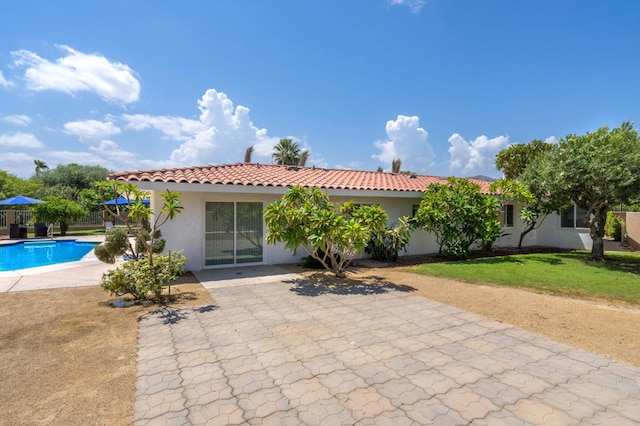 exterior space featuring a patio area, a fenced in pool, and a lawn