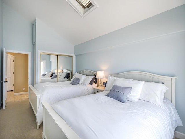 bedroom featuring light colored carpet, a closet, and lofted ceiling with skylight